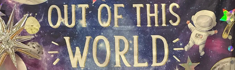 Out Of This World banner from prom used as photo op background